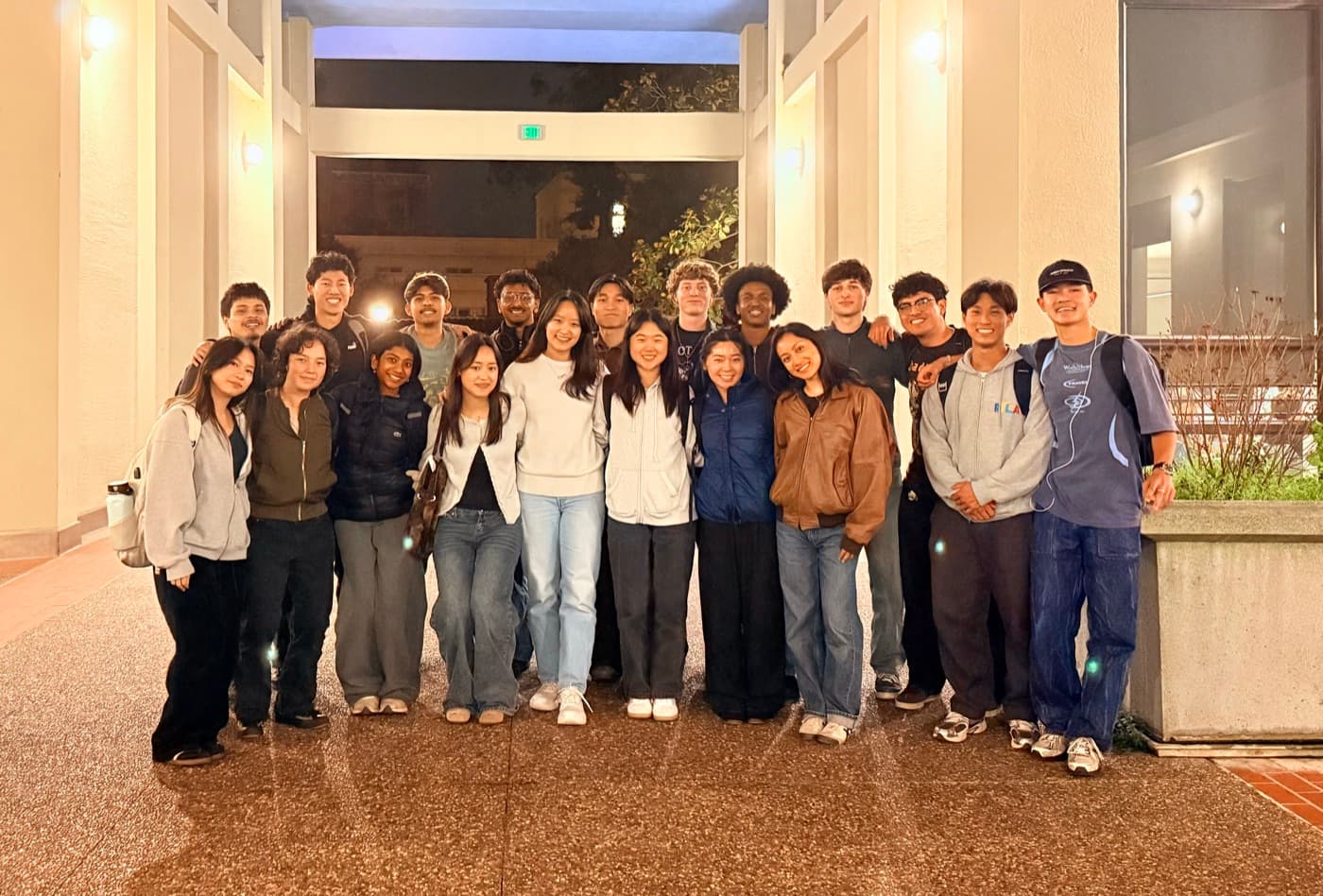 The Social Good committee gathered for a group photo outside a campus building in the evening